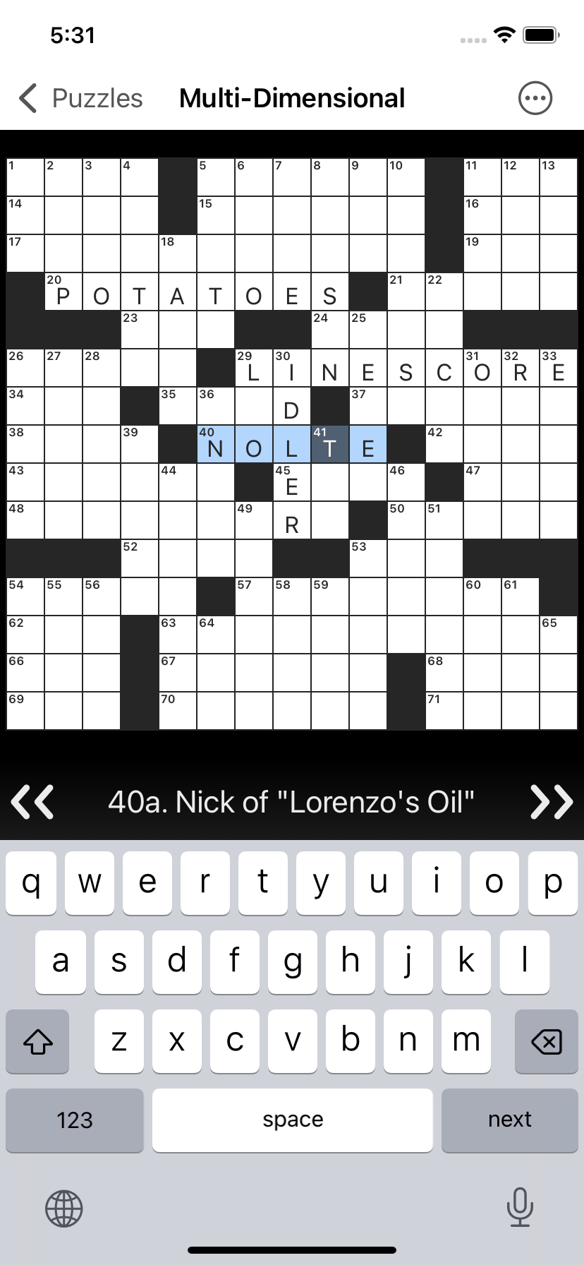 Screenshot of Black Ink crossword app for iOS, showing a crossword grid with some answers filled, the standard iOS keyboard, and a clue navigator.